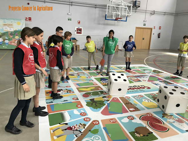 niños y niñas jugando a una oca gigante