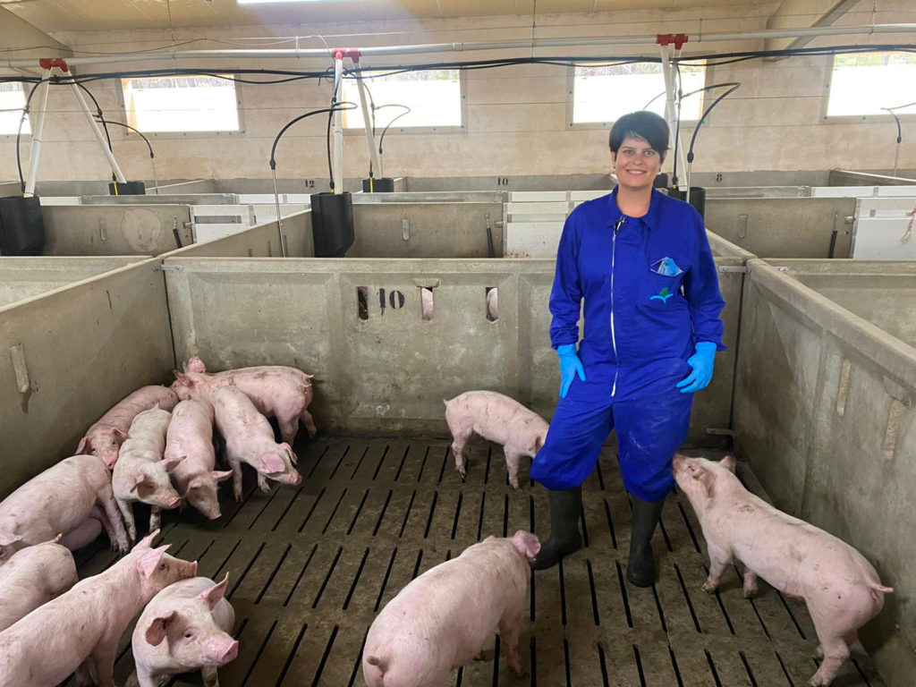 Marta en el interior de su granja con cerditos