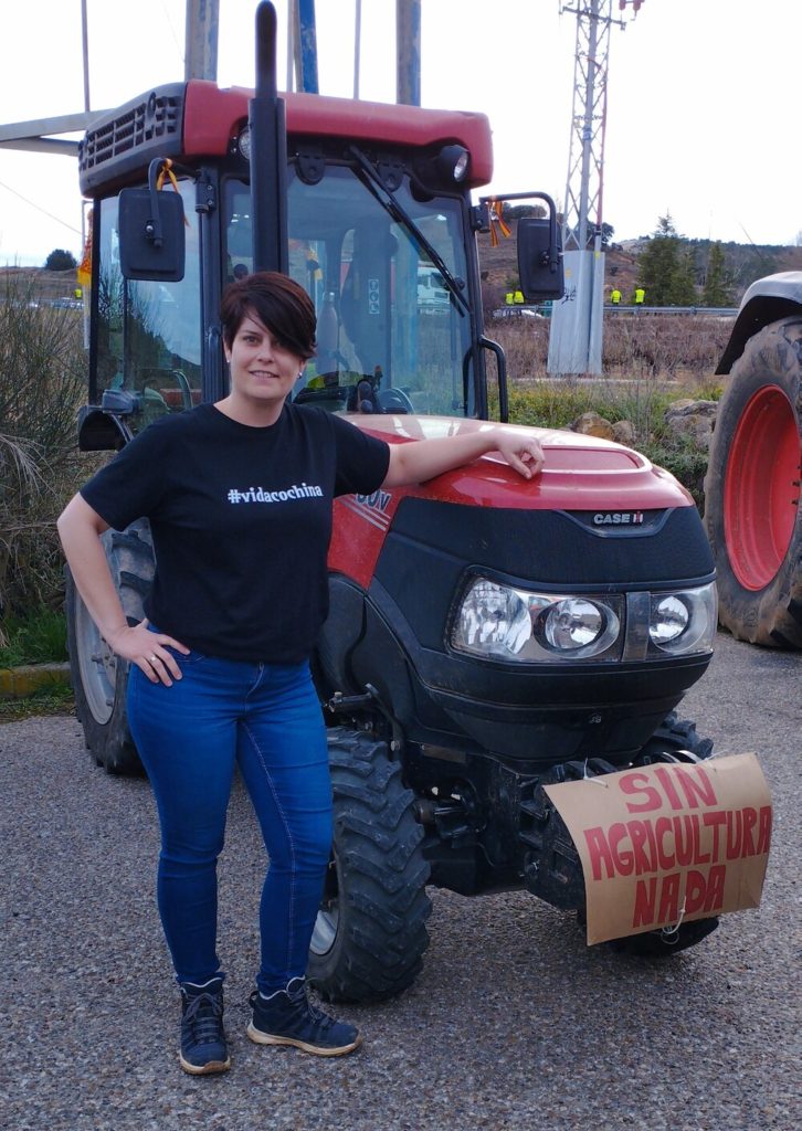 Marta delante de un tractor